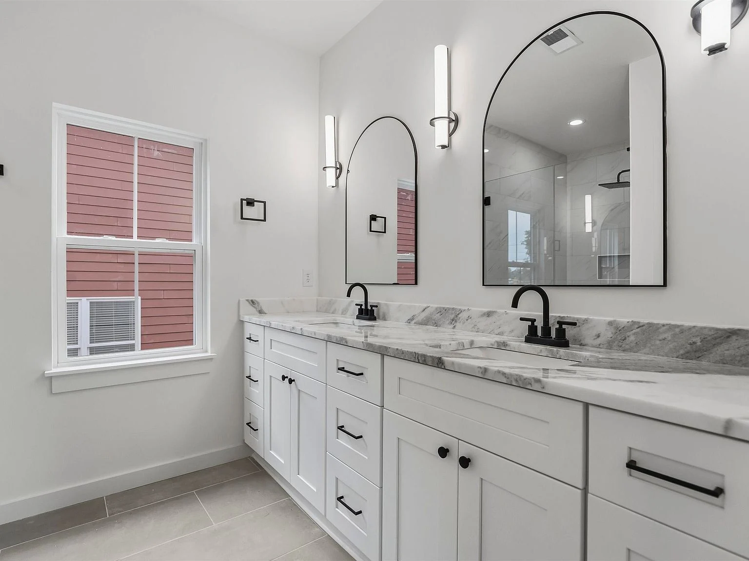 Primary bathroom with double vanity and large mirrors
