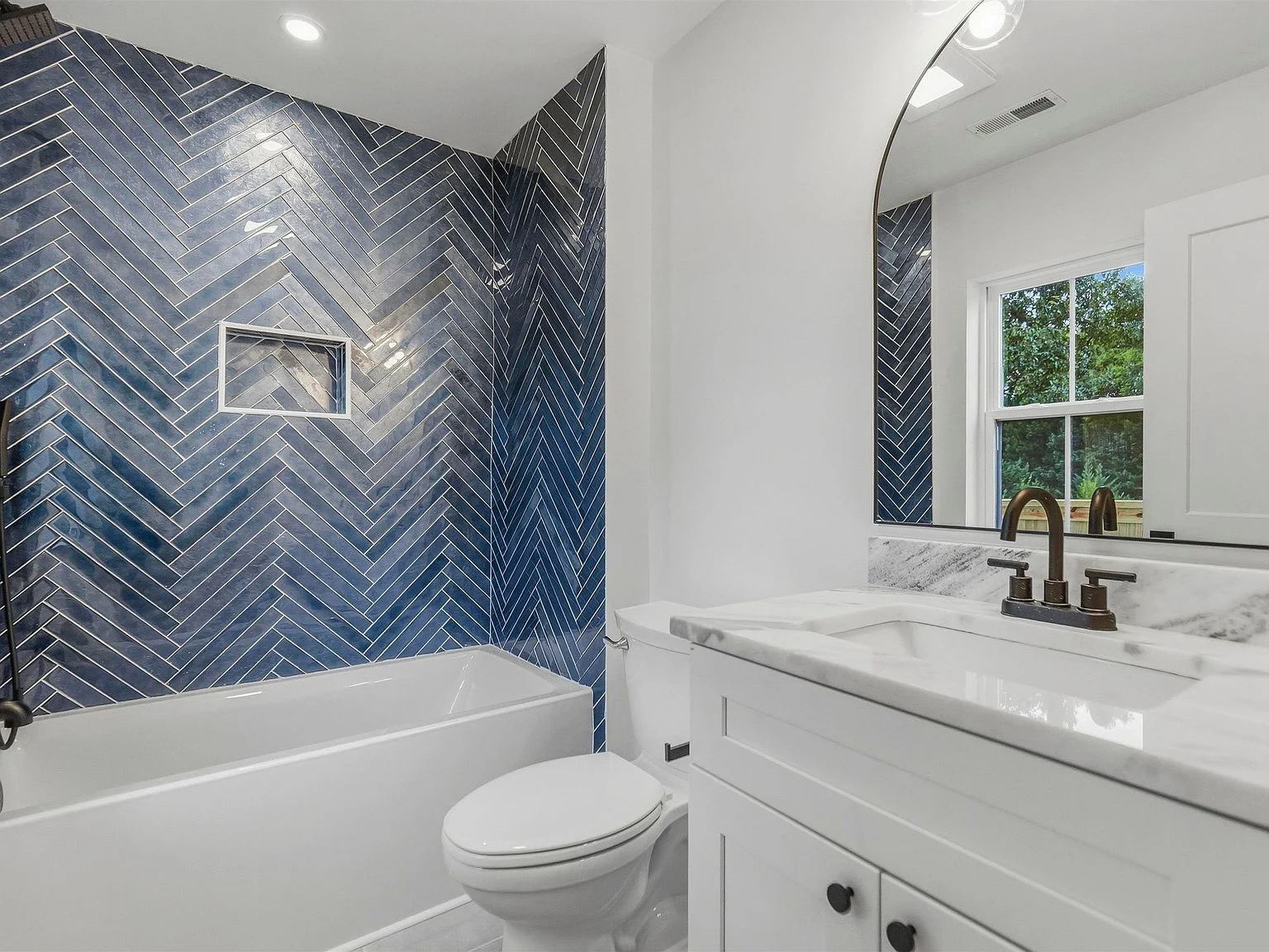 Guest bathroom with blue tile and patterned floor