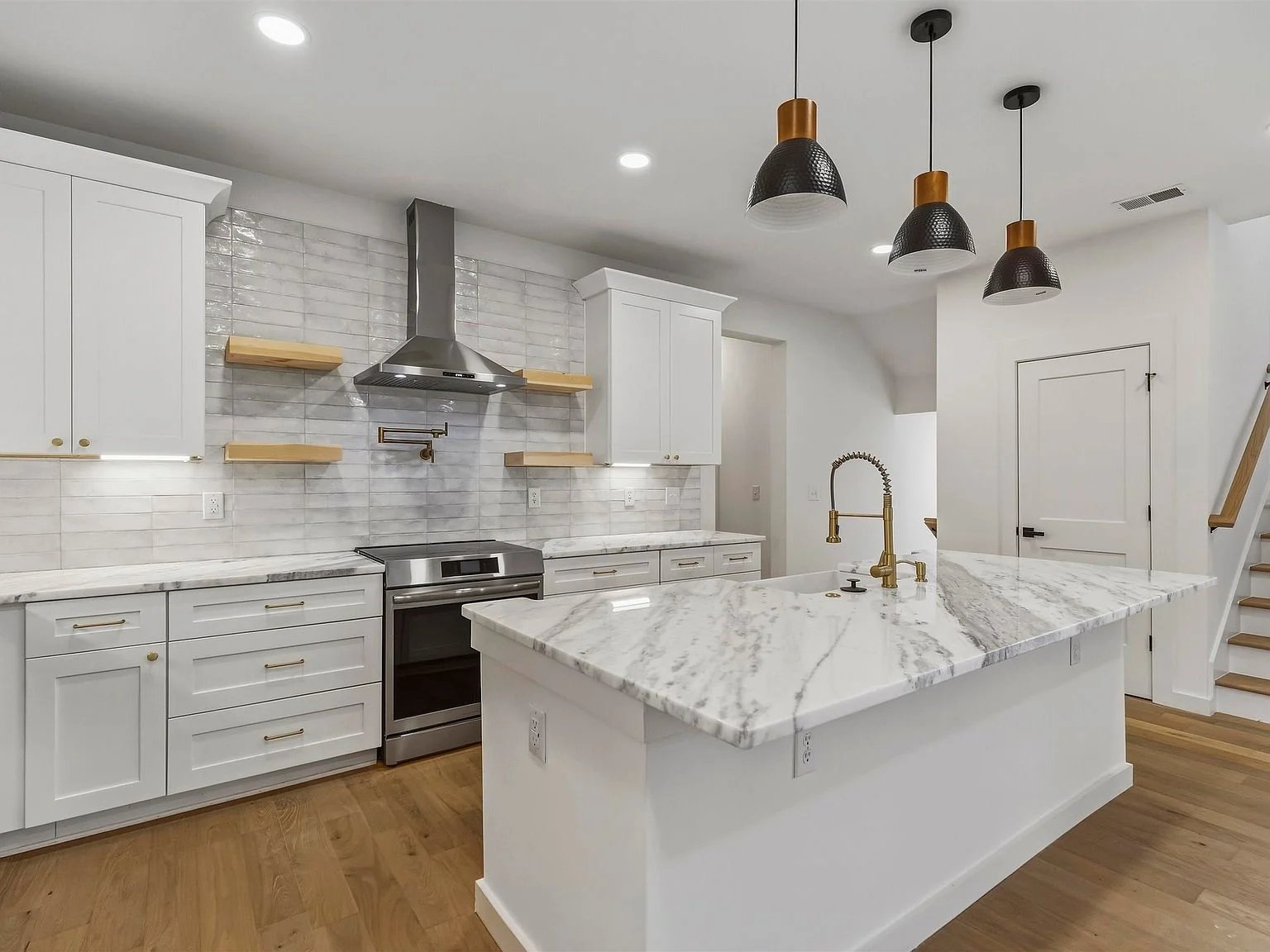 Kitchen with a large island, pendant lighting, and wood floors