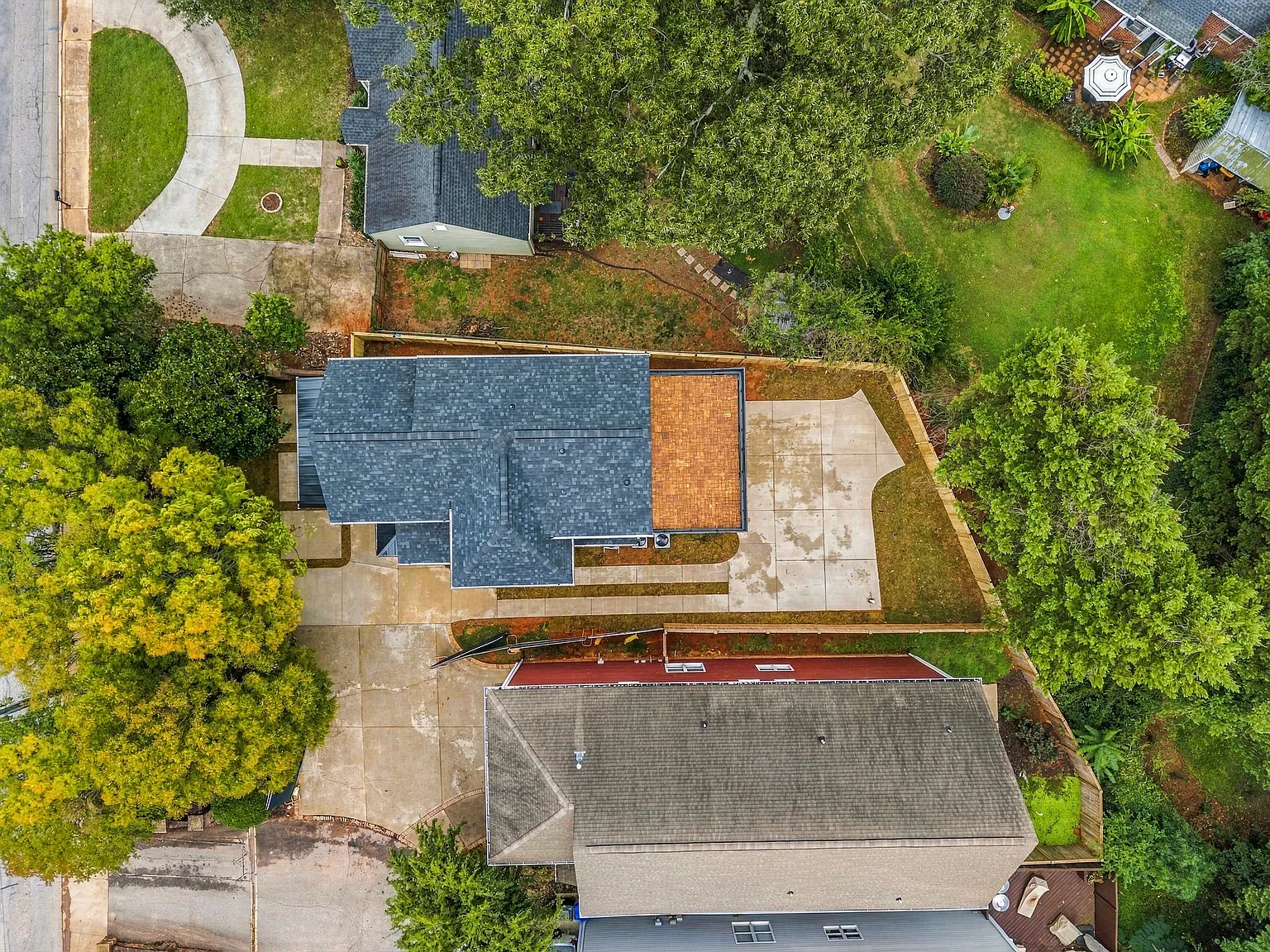 Full overhead view of the Rutherford residence showing the home, rooftop deck, driveway, and surrounding lot