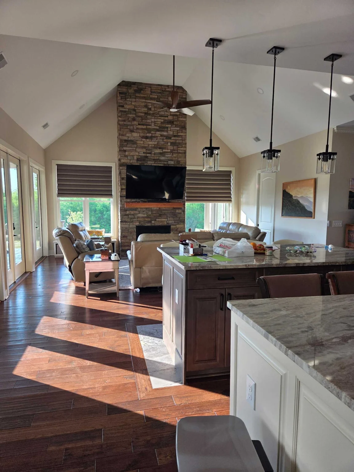 Vaulted living room, stone fireplace, and kitchen island at the Marietta residence